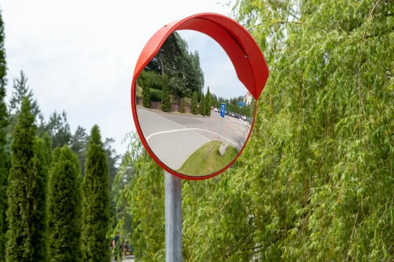 Oglinda stradala rutiera convexa cu copertina portocalie, montata pe stalp la o intersectie